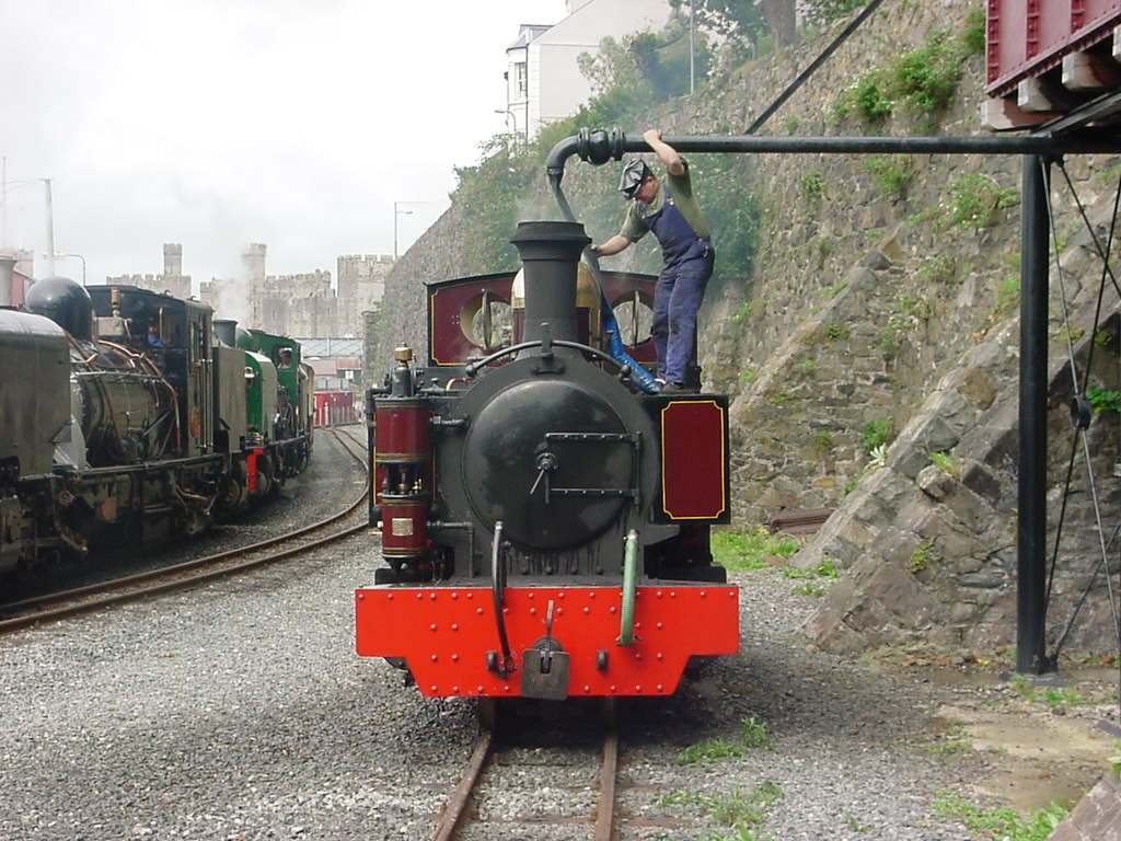 Russell takes water at Caernarfon during the August 2000 visit to the northern end of the Welsh Highland. Caernarfon Castle is in the background, as are two of the WHR(C)