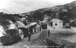 small locomotive; footplate staff in conversation with small woman wearing hat etc