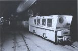 white cuboidal locomotive in a dark tunnel