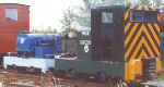 cabless blue Cnicht surrounded a by green Simplex and a bauxite orange brake van